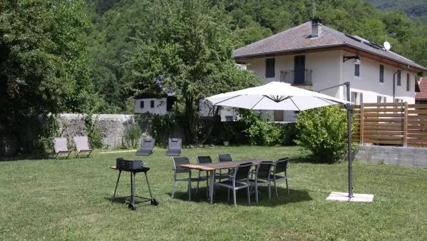 Jardin avec barbecue et chaises longues