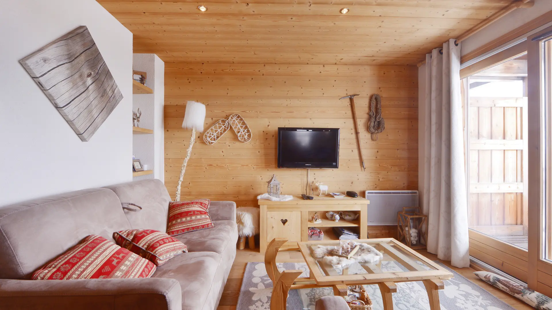 Salon avec TV, richement décoré en style savoyard