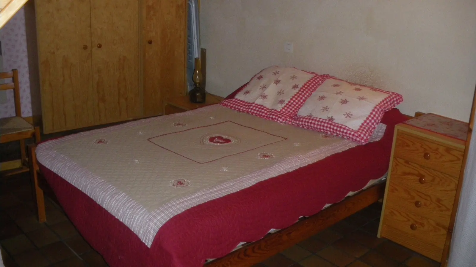 Chambre à coucher avec lit double, ameublement bois, sol carrelé