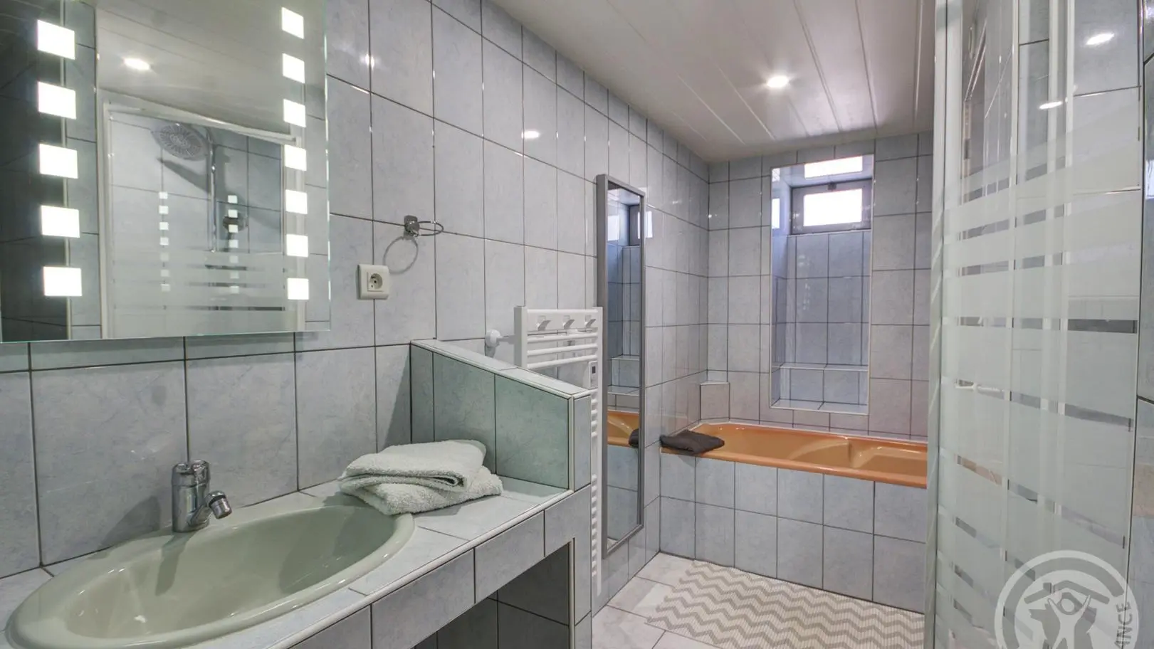 Salle d'eau au rez-de-chaussée avec douche et baignoire.