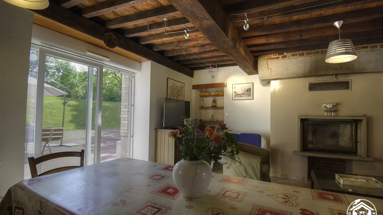 Vue sur le salon avec sa cheminée de la cuisine