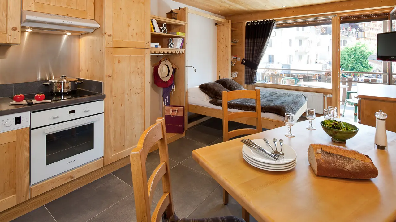 Séjour avec lit double et télévision, salle à manger et cuisine/Living room with a double bed and a television, dining room and kitchen-Forclaz C n°32-Le Grand-Bornand