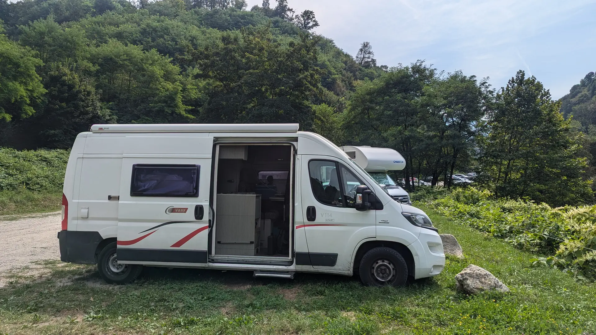 Camping-car blanc sur une aire naturelle herbeuse