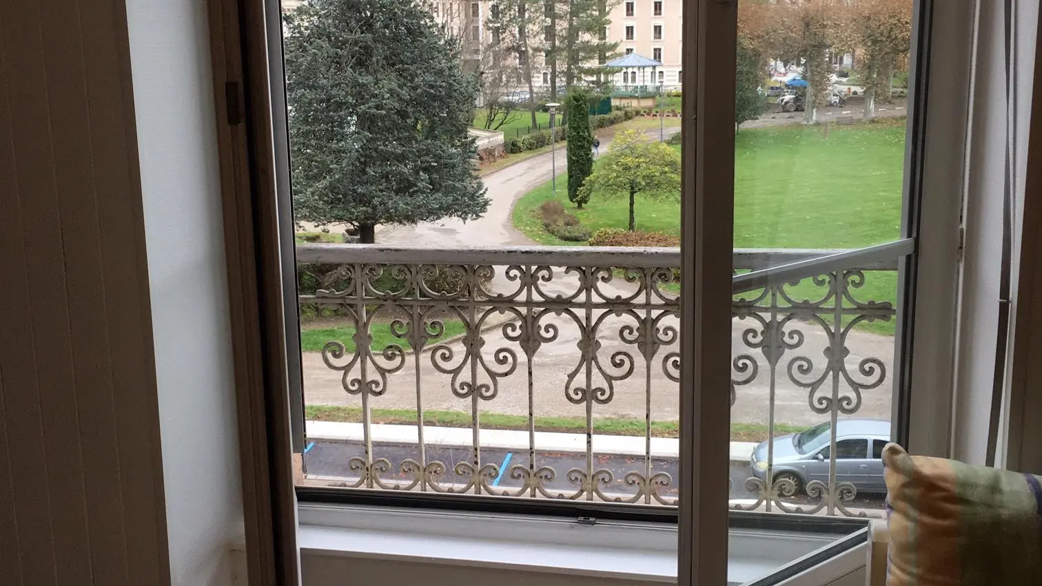 La pièce est éclairée par une grande fenêtre avec une balustrade en fer forgé qui offre une vue panoramique sur le Grand Hôtel et le Parc d’Uriage.