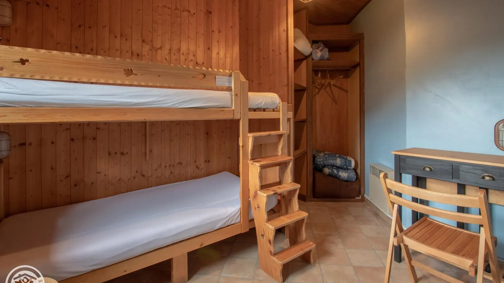 Petite chambre avec 2 lits 90cm superposés et un bureau.