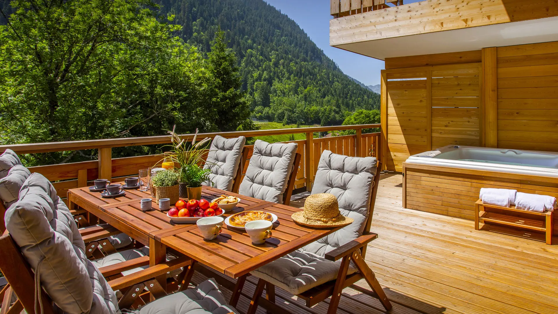 Terrasse avec son salon de jardin et bain à remous en été