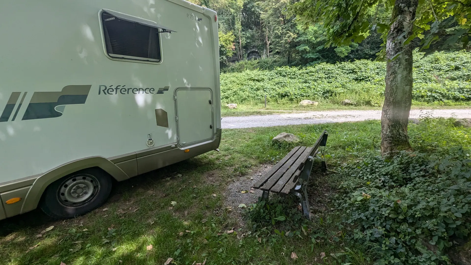 Camping-car blanc sur une aire naturelle herbeuse