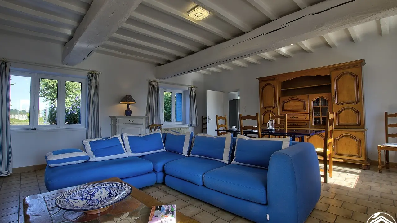 Grand salon avec de très belles poutres blanches et ses couleurs bleues : une envie de voyager ...