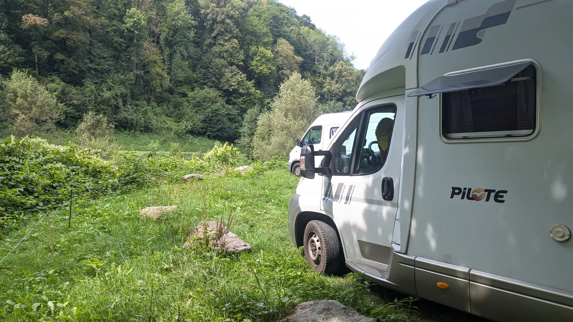 Camping-car blanc sur une aire naturelle herbeuse