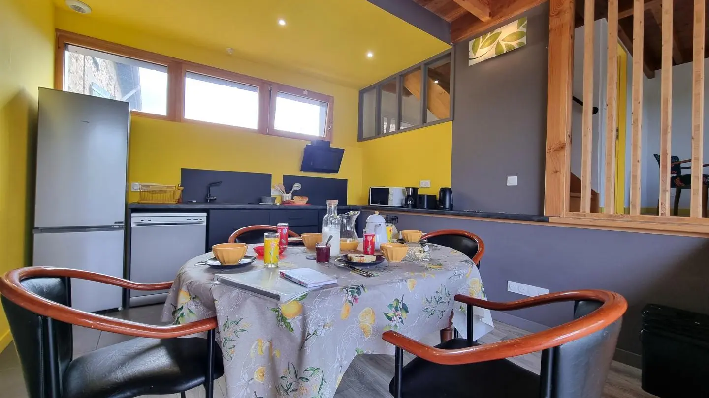 Pièce à vivre avec cuisine ouverte sur l'espace repas.