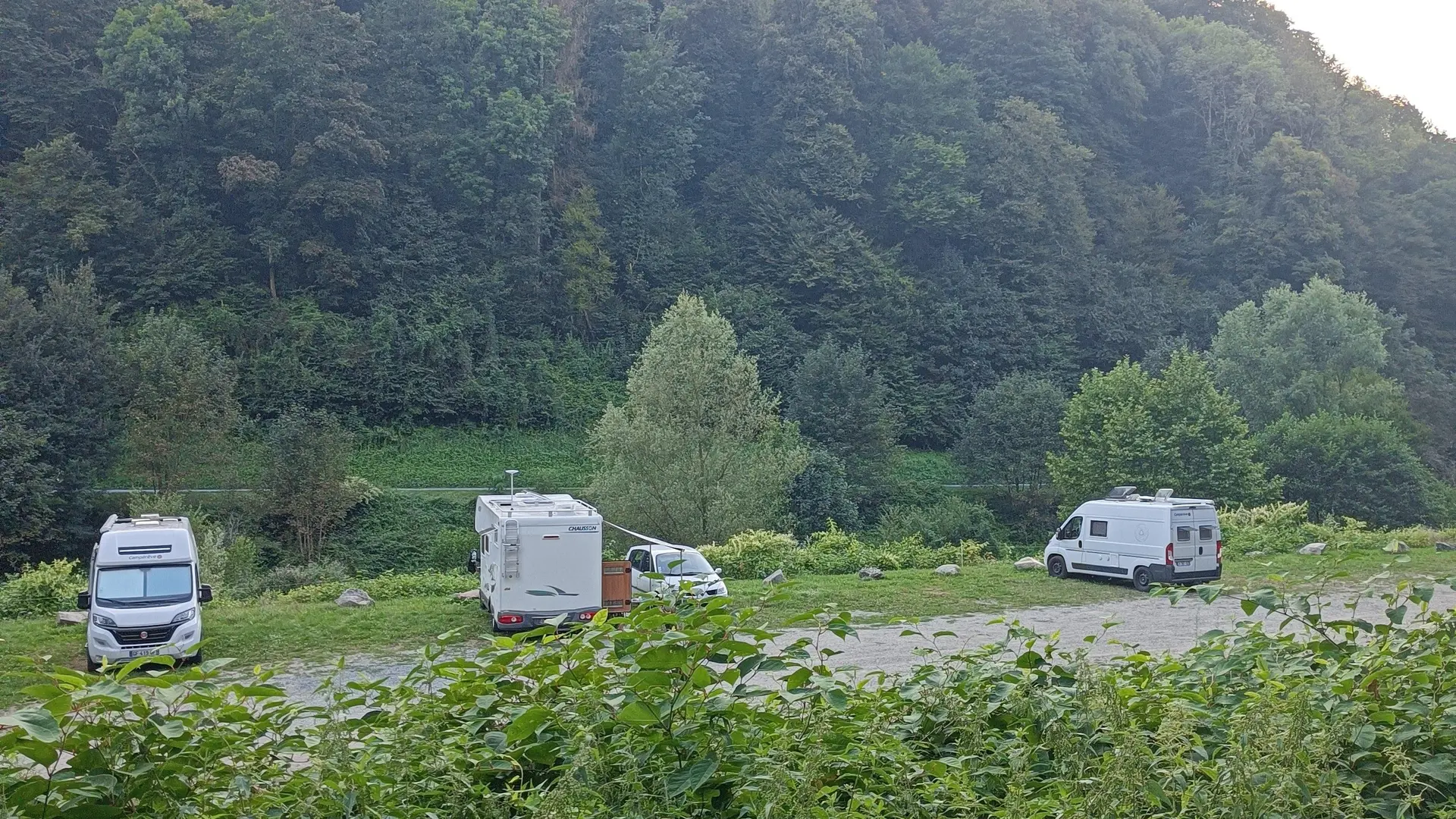 Camping-car blanc sur une aire naturelle herbeuse