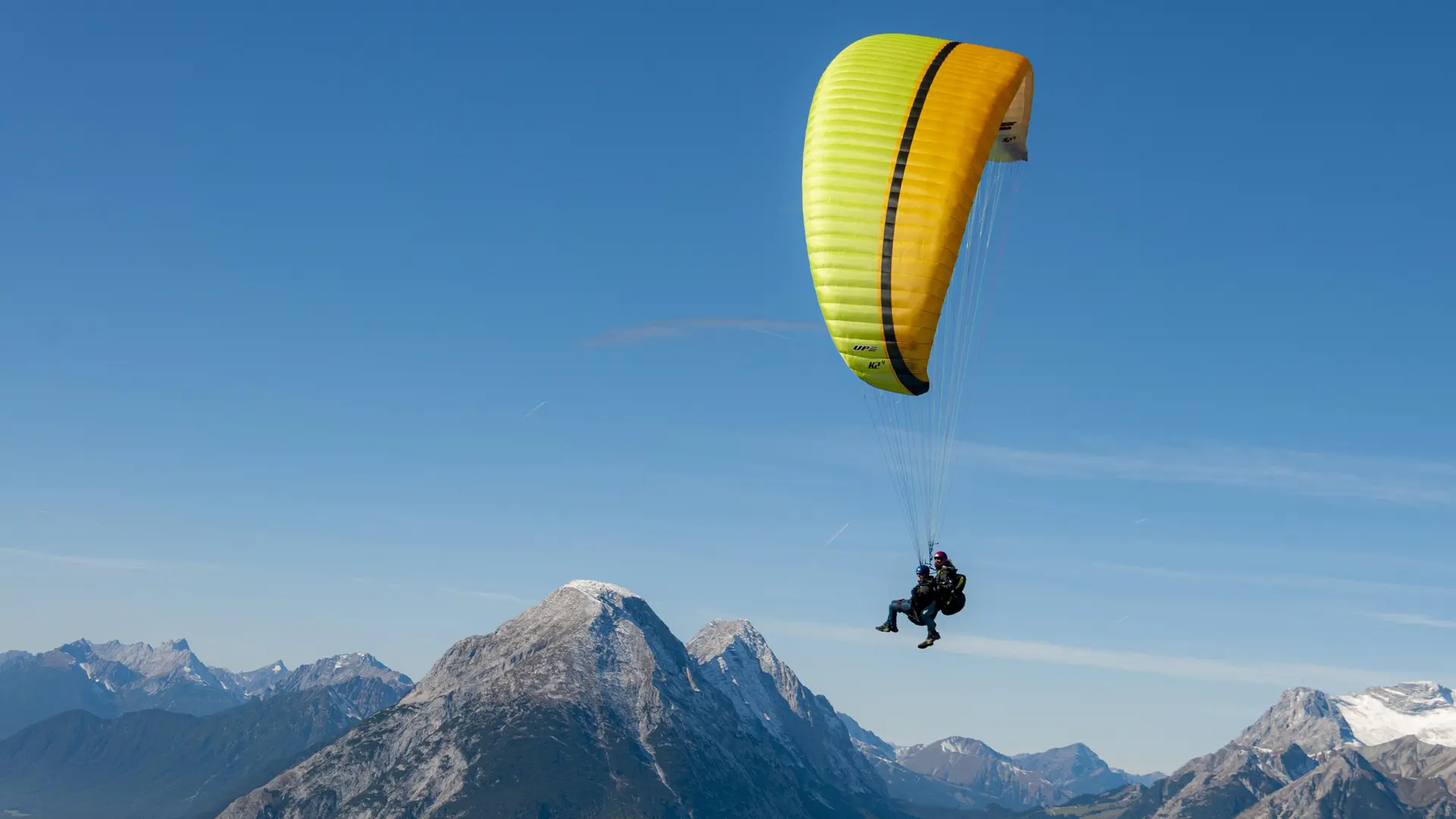Parapentiste en plein vol, survolant de hauts sommets
