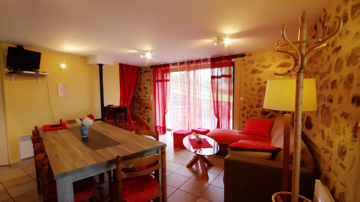 Salle à manger et coin salon.
Baie donnant sur une terrasse avec barbecue.