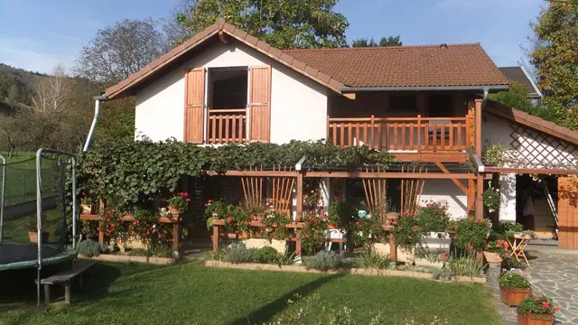 C'est une maison de campagne avec un grand jardin. Une terrasse en bois donne accès à un espace extérieur aménagé.