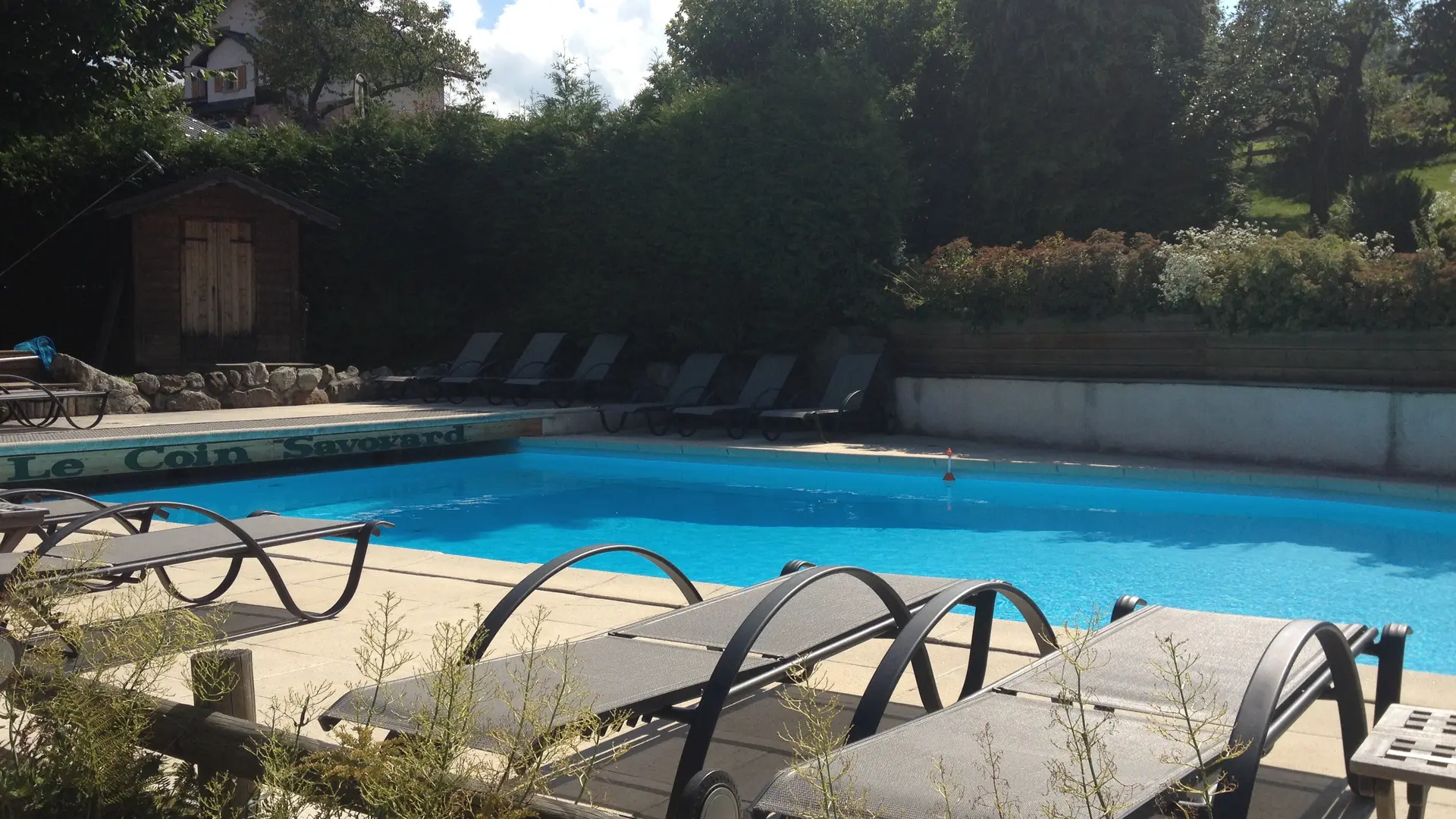 Transats au bord de la piscine du Piscine du u restaurant le Coin savoyard