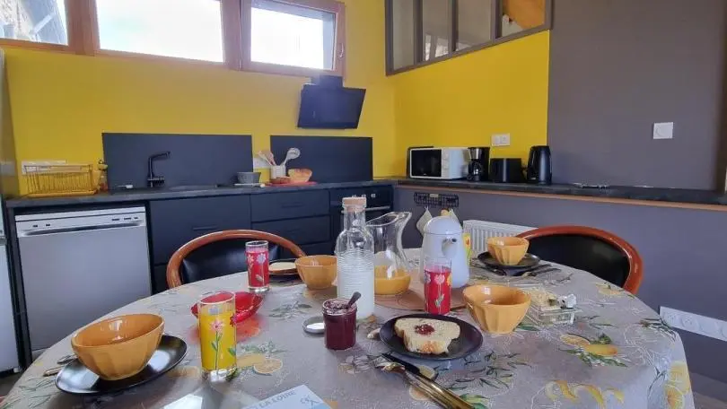 Pièce à vivre avec cuisine ouverte sur l'espace repas.