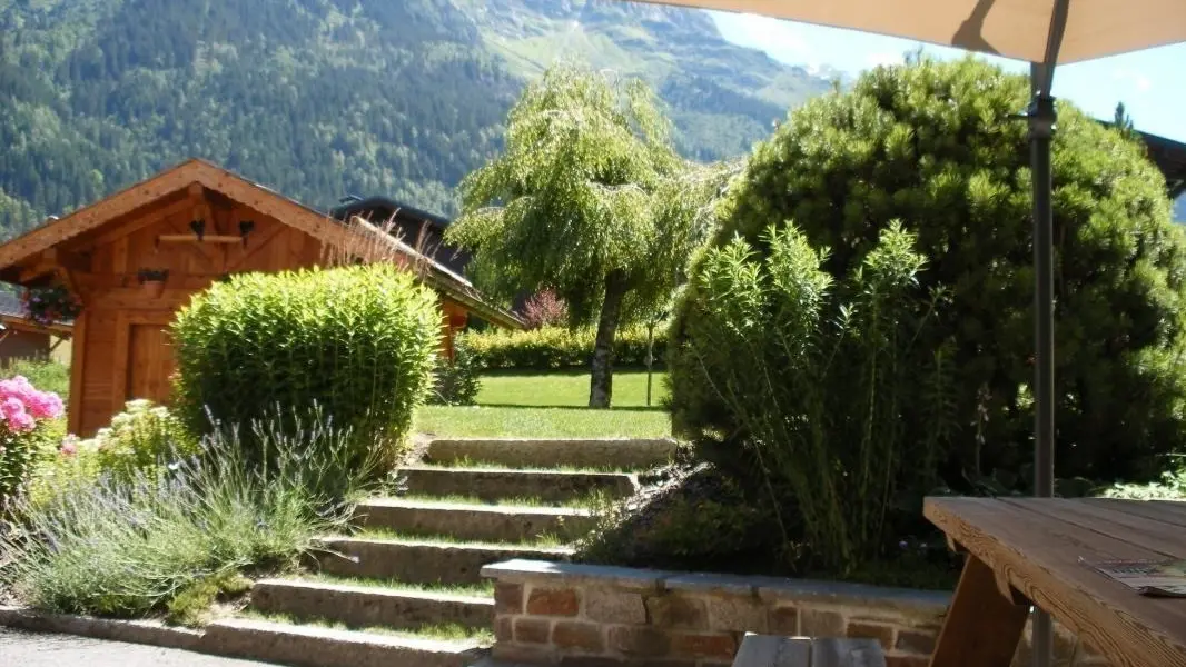 terrasse privative équipée d'une table pic nique et d'un grand parassol