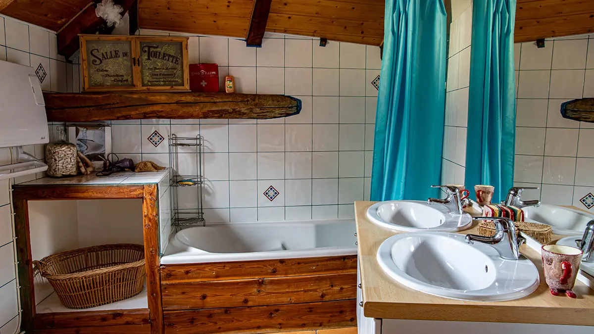 Bright bathroom with bathtub and sink, electric heater, decorated with tiles and wood