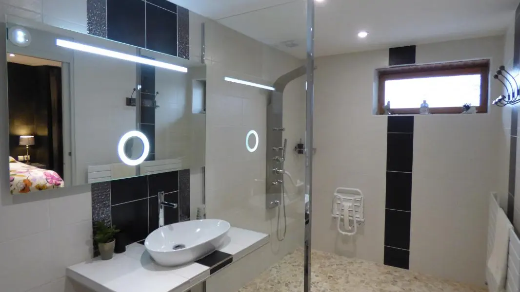Salle d'eau aménagée pour recevoir des personnes à mobilité réduite
dans la chambre 
