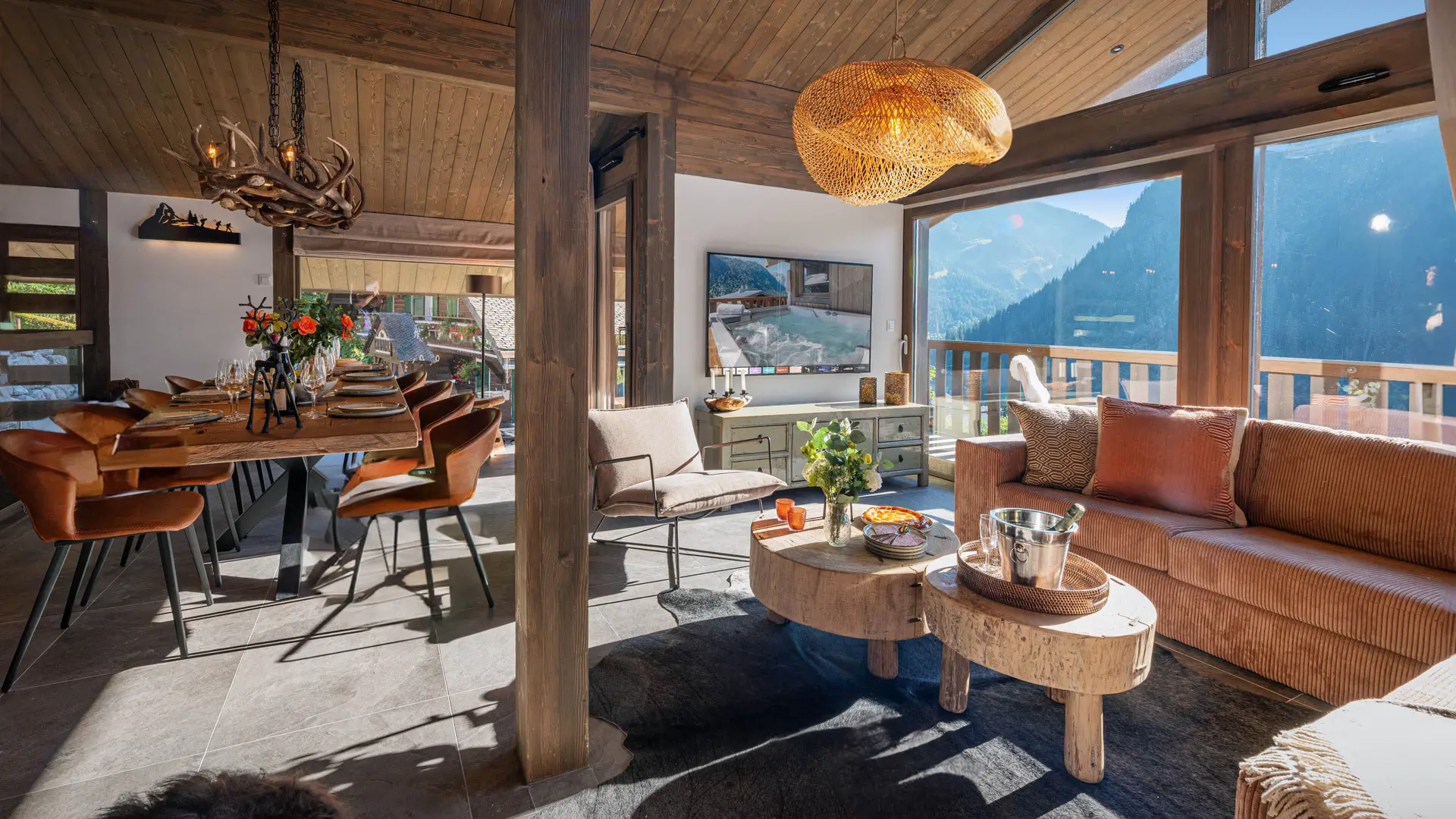Vue du séjour et salle à manger avec grandes baies vitrées donnant sur le balcon, vue sur les montagnes