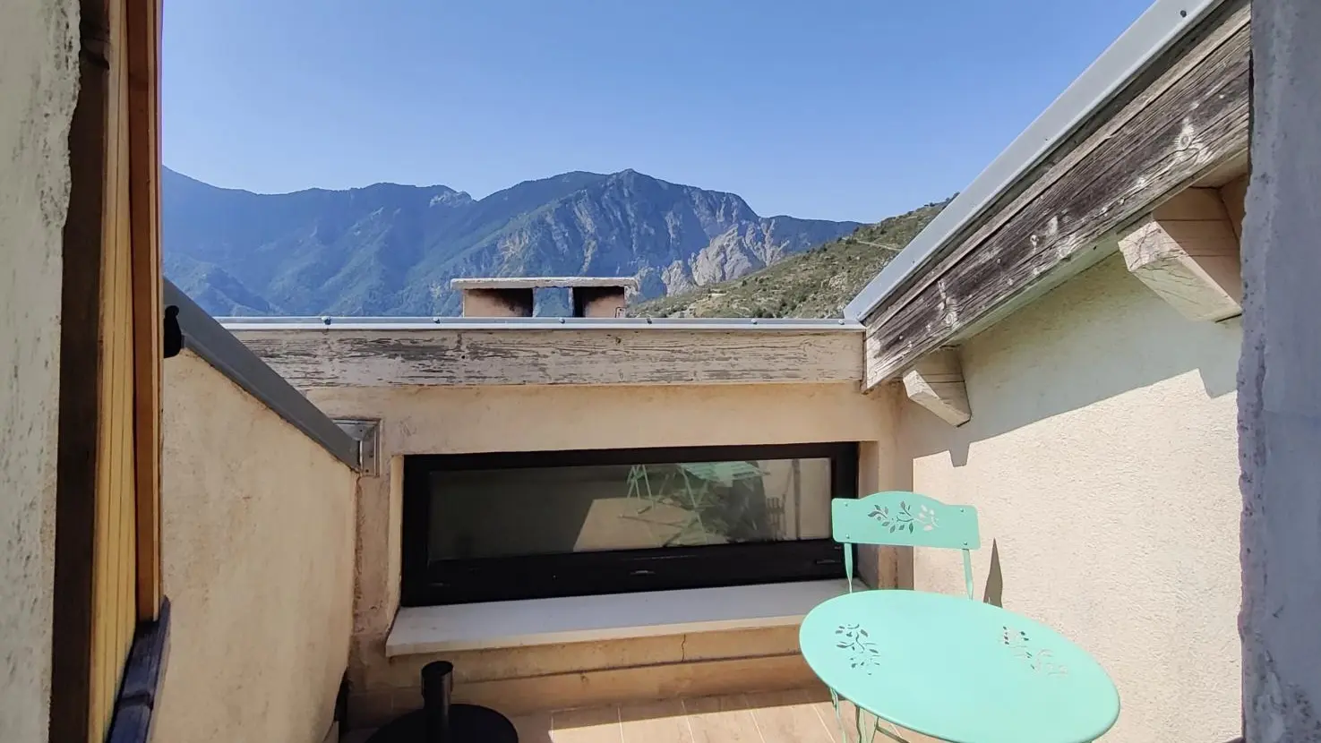 Terrasse avec vue sur la montagne. A disposition un parasol ainsi qu'une table et des chaises - Le Planet 2 d'Ilonse - Gîtes de France Alpes-Maritimes