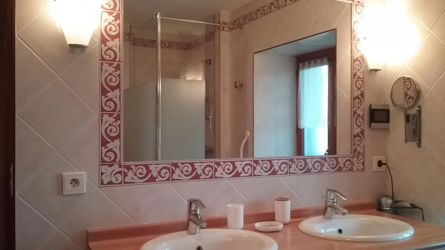 Salle de bains avec 2 vasques et 1 fenêtre.