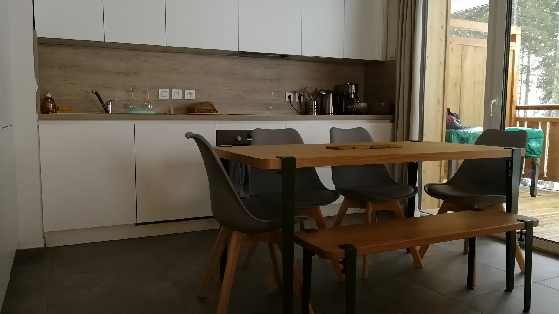 Espace repas dans la pièce à vivre à côté de la cuisine et accès au balcon