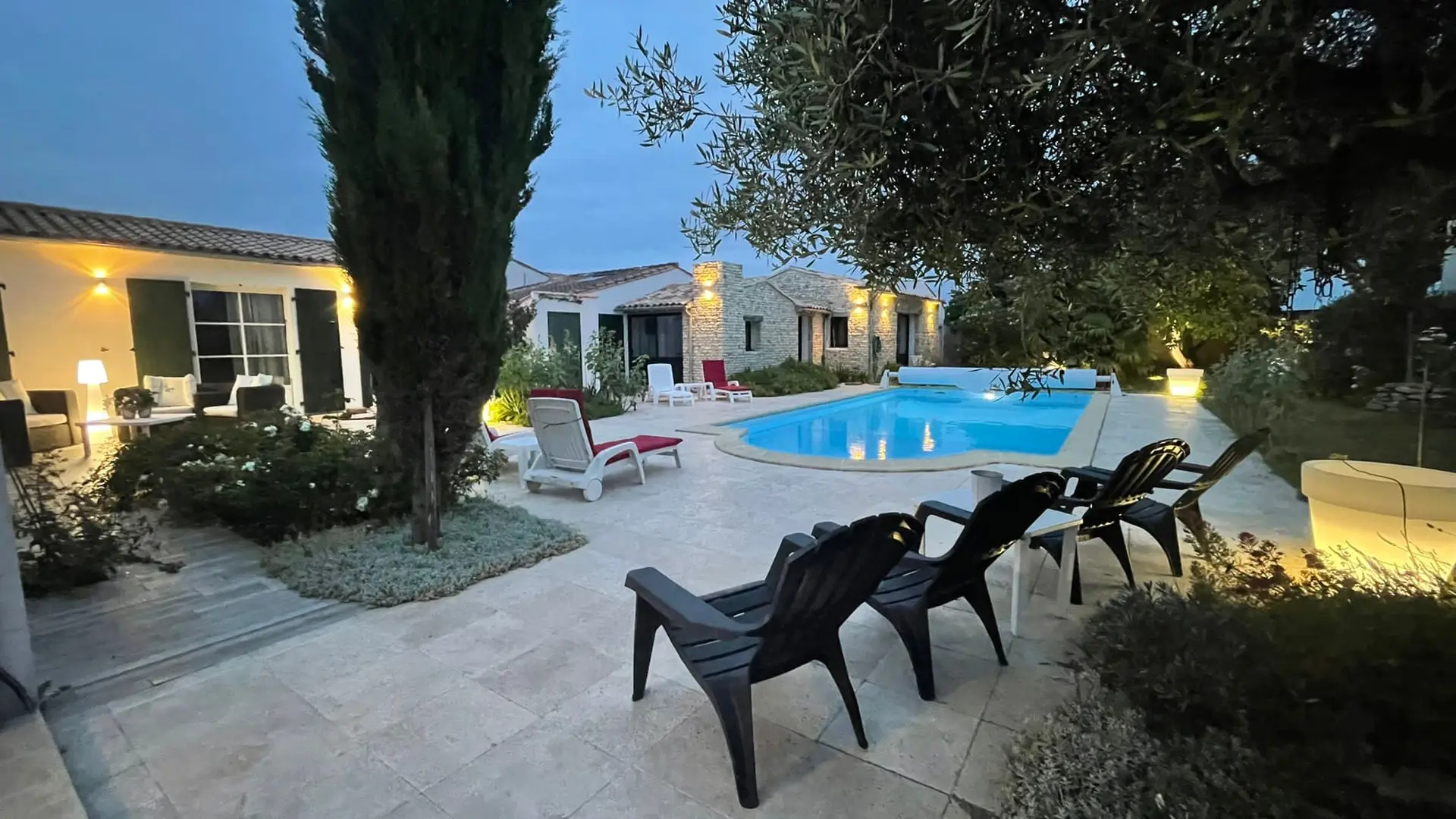 swimming pool and house with exterior lighting