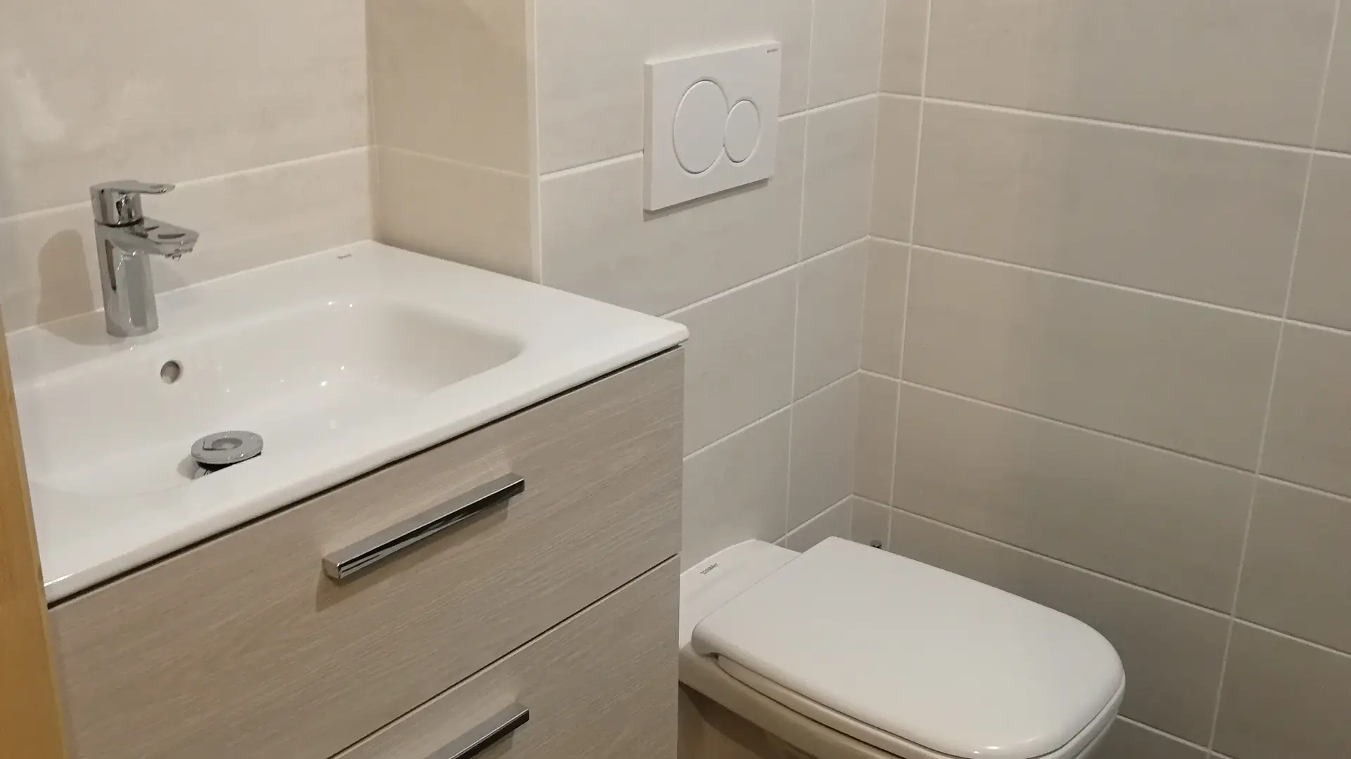 Salle de bains avec vasque et son meuble et toillettes