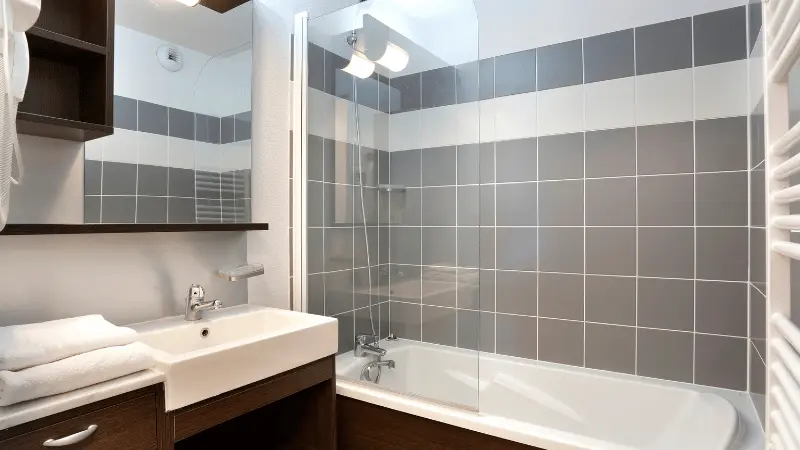 Modern apartment bathrooms with bathtub, sinks, and mirrors