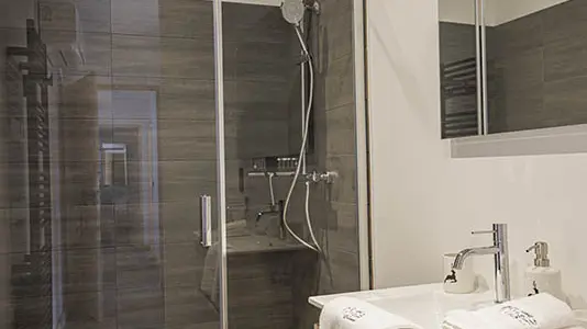 salle de bains, grand bac à douche lumineux, évier, ameublement bois, sol carrelé