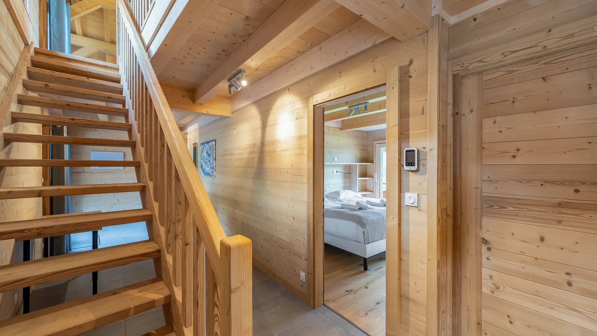 Escalier en bois faisant la liaison entre les étages, chambre à droite