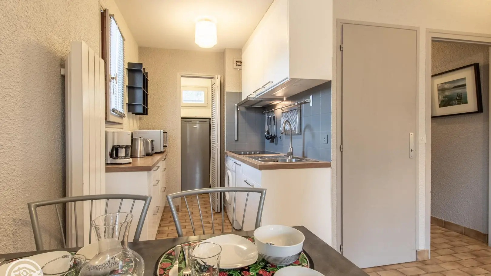 Espace repas et cuisine ouverte avec cellier