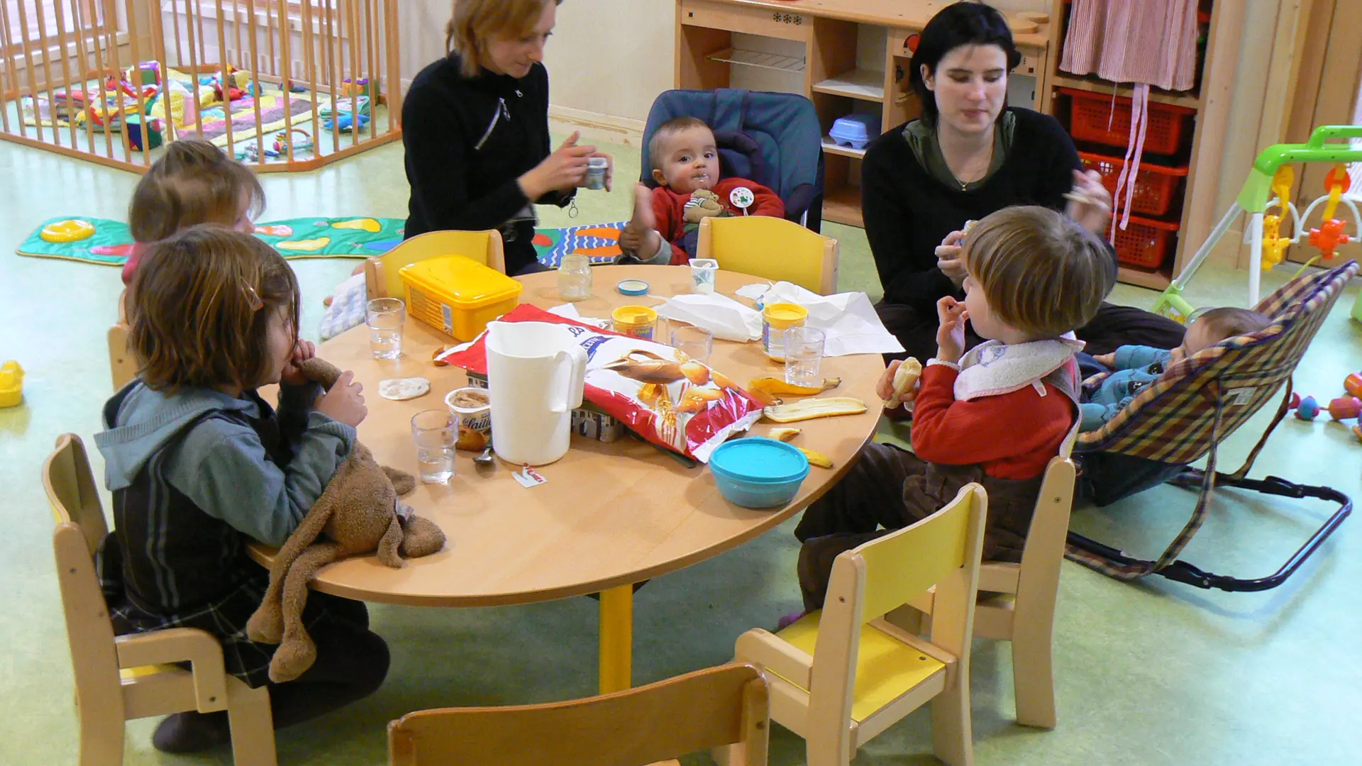 Enfants assis autour d'une table basse pour prendre le goûter