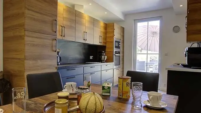 Cuisine spacieuse et fonctionnelle avec équipement complet donnant sur la terrasse.