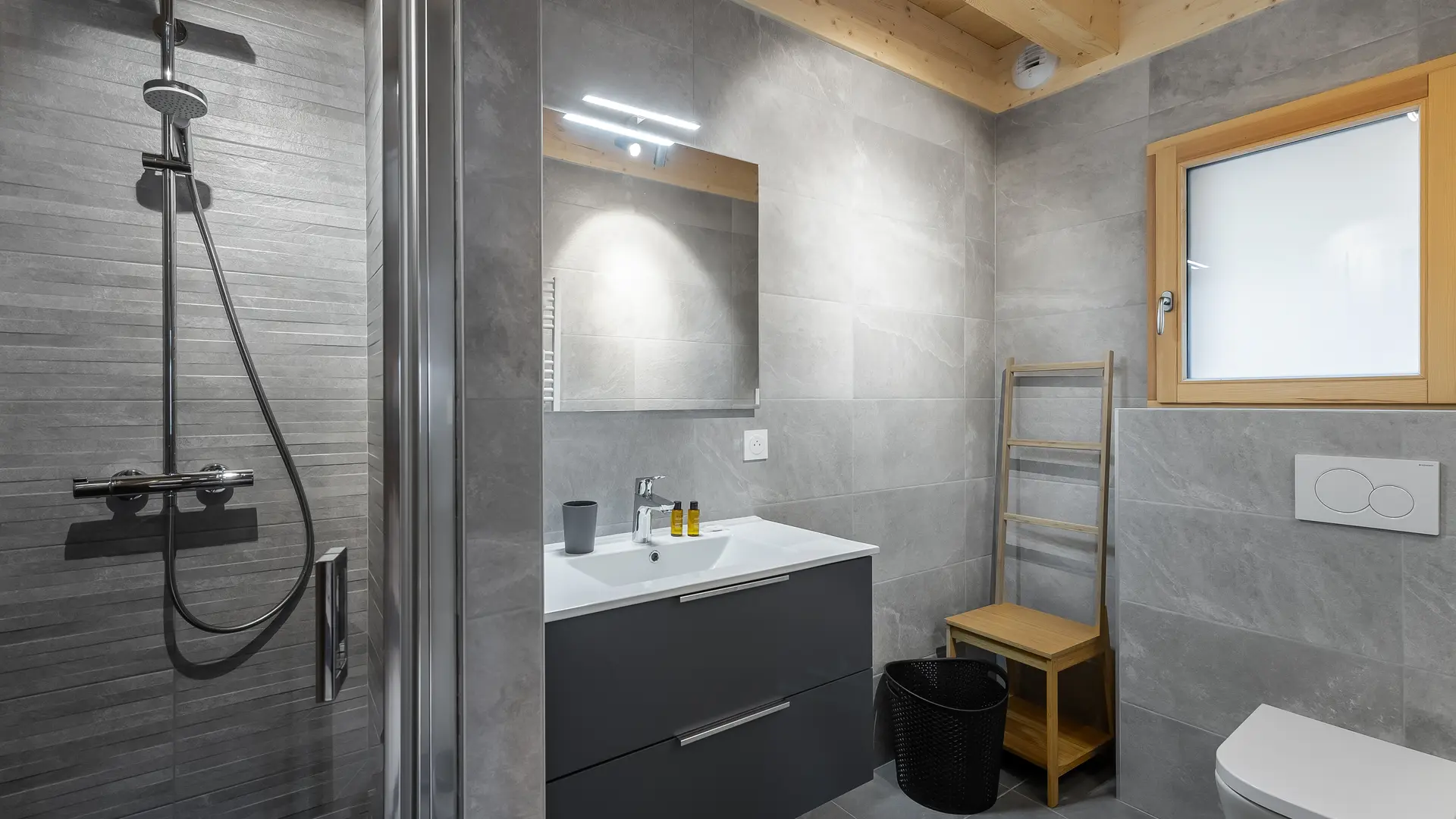 Salle de bains avec douche, grande vasque et son meuble, grand miroir, toilettes, fenêtre