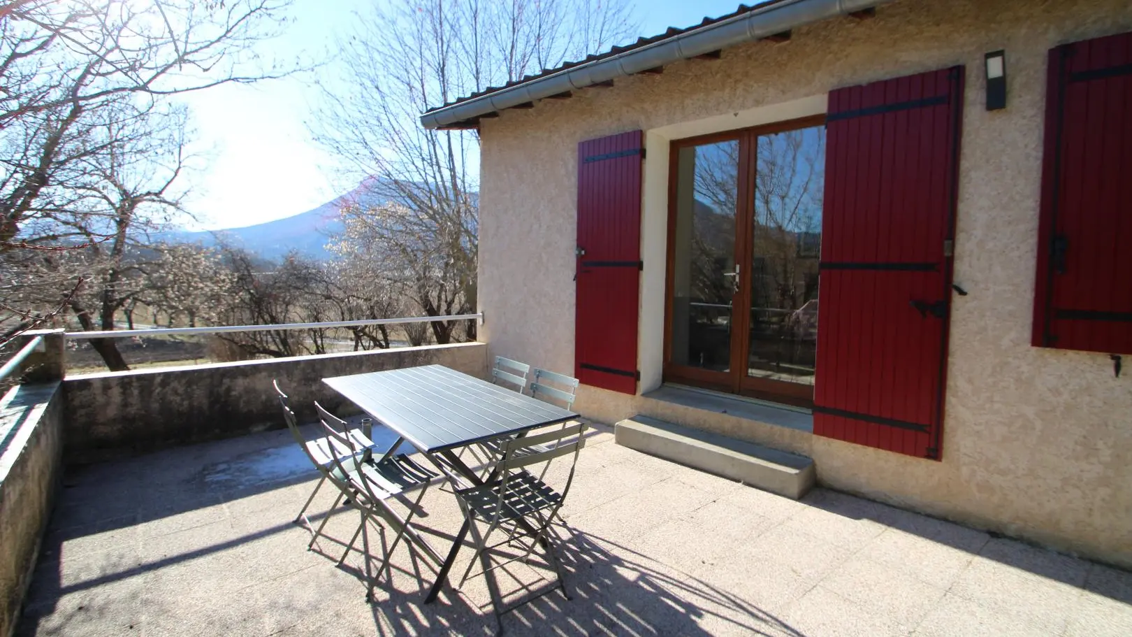 Vaste terrasse aménagée devant l'entrée du gîte et exposée Sud/Est