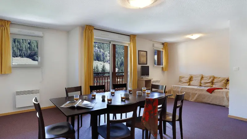 Apartment living room with dining table, sofa, TV, wooden furniture, window