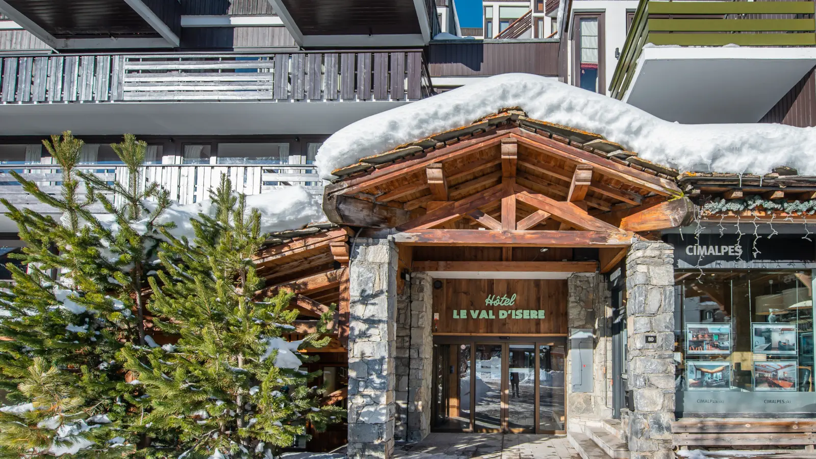 Entrée de l'hôtel avec de la neige et des sapins