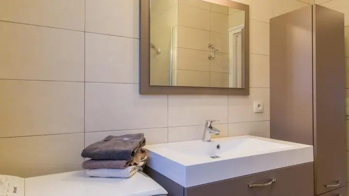 Salle d'eau : vasque sur meuble, douche à l'italienne, lave-linge.