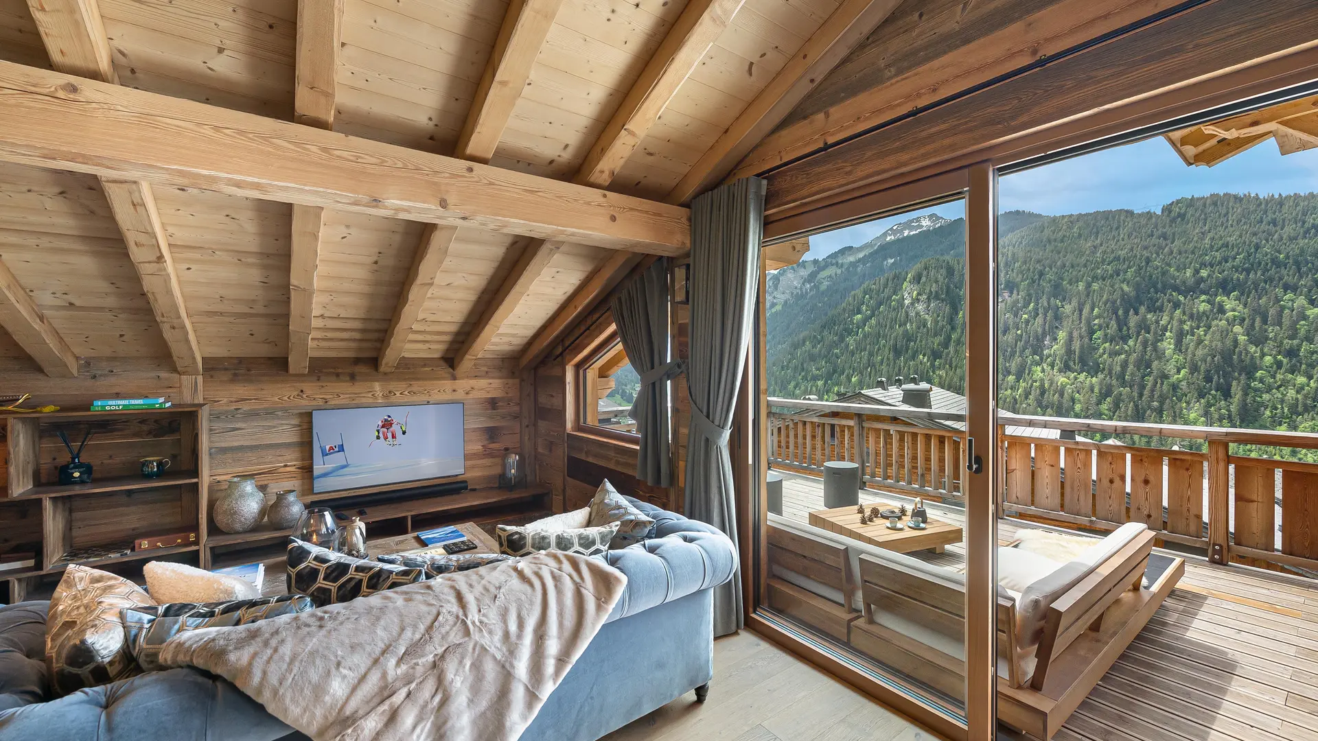 Espace détente télévision avec canapés, accès à la terrase par une grande baie vitrée