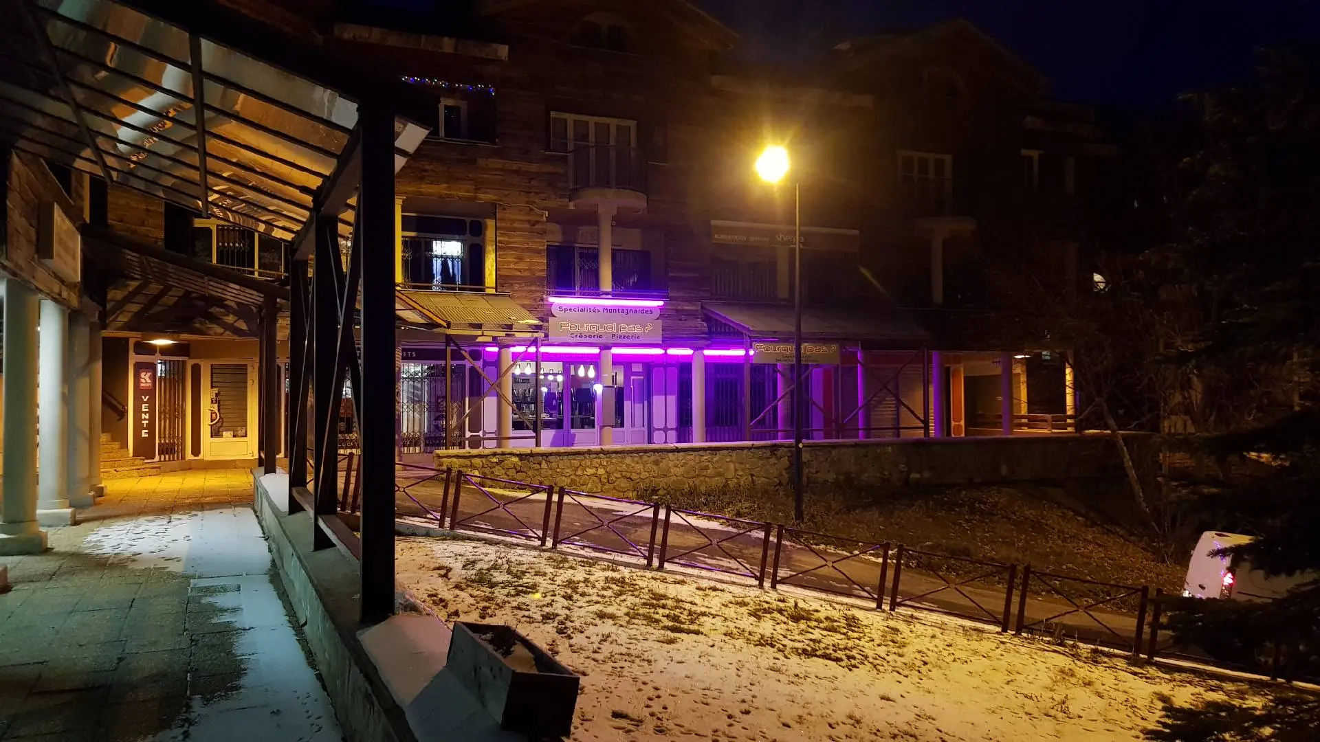 Front of the late-night restaurant with an outdoor terrace furnished with tables and chairs. Sign with the inscription: Pourquoi pas ? Creperie Pizza Mountain specialties