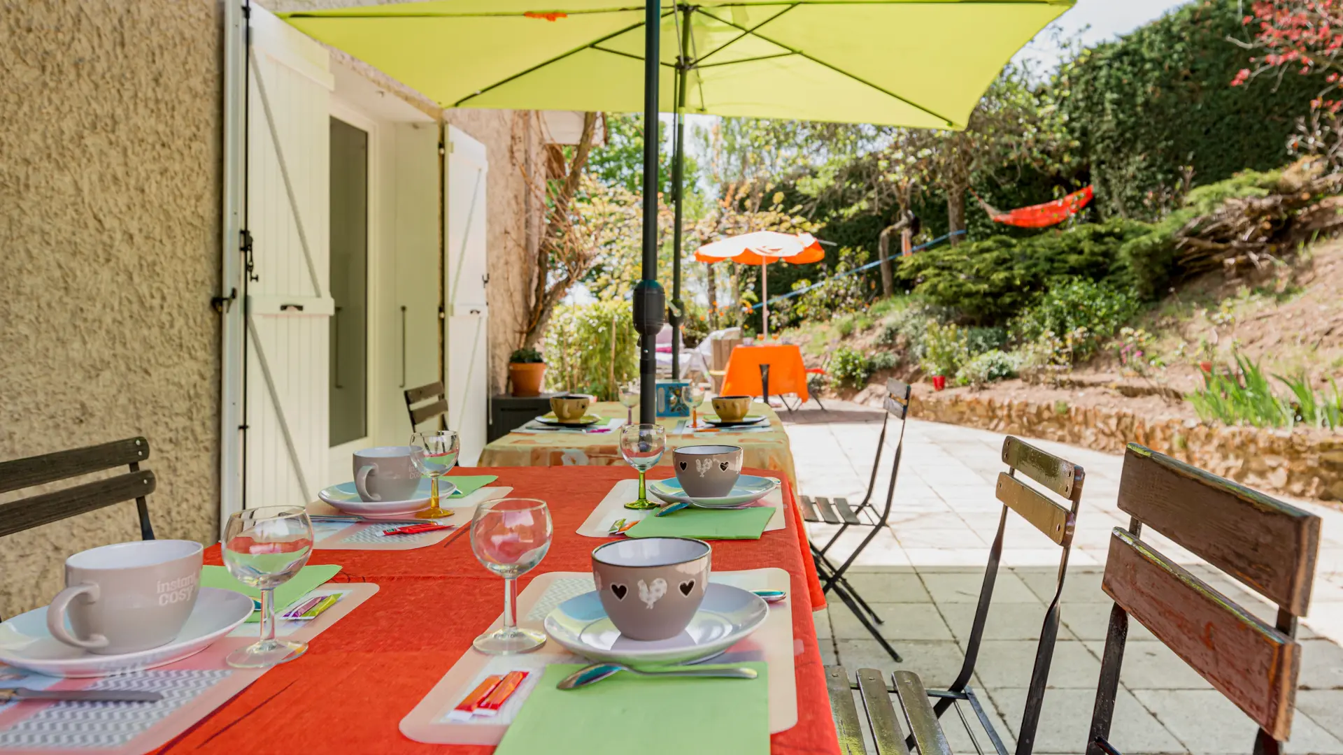 Petits déjeuners en terrasse sous parasol jaune et bleu, ambiance colorée