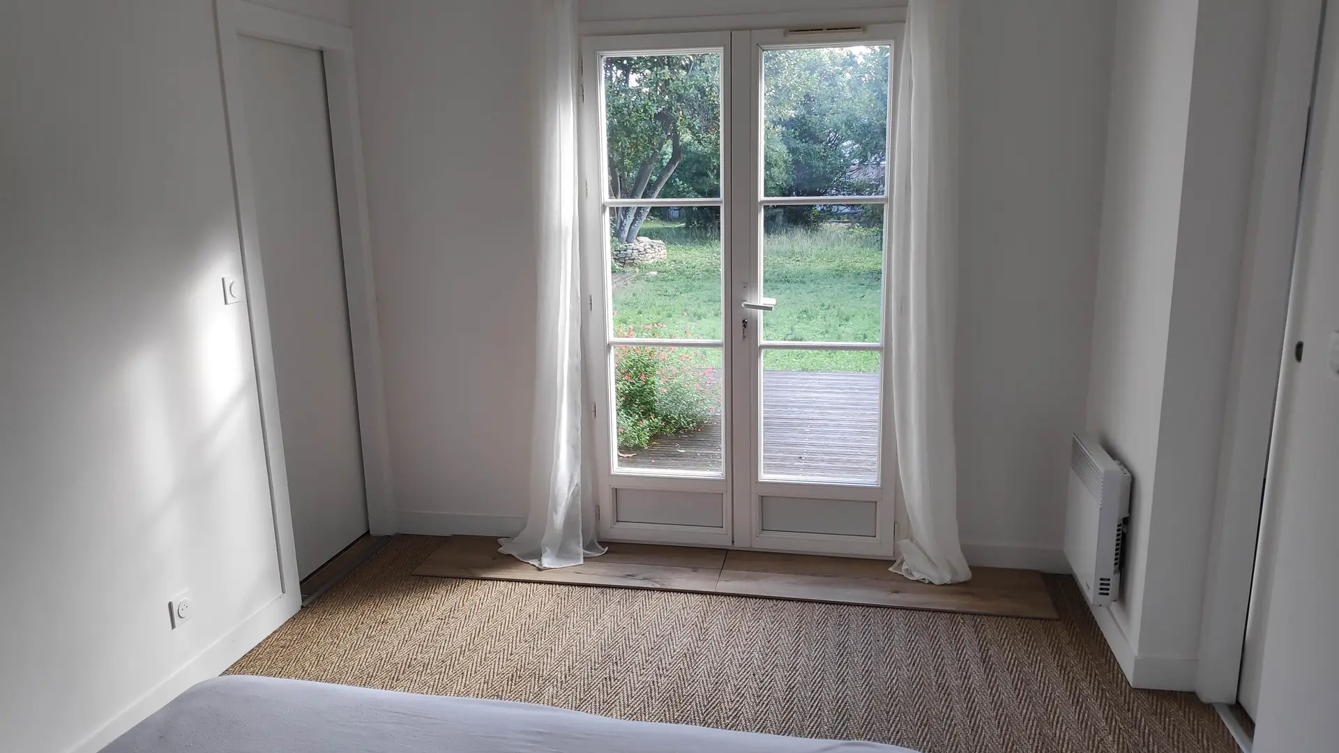Schlafzimmer 2 mit Doppelbett und Blick auf den Garten