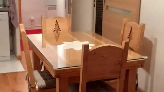 Séjour lumineux avec canapé, table à manger, coin cuisine, ameublement bois, parquet au sol