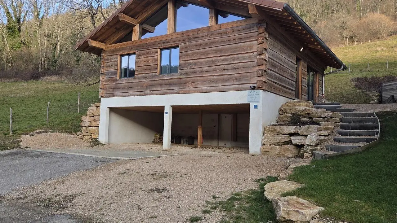 Sous le chalet, places de parking. L'accès au gîte se fait par les escaliers extérieurs