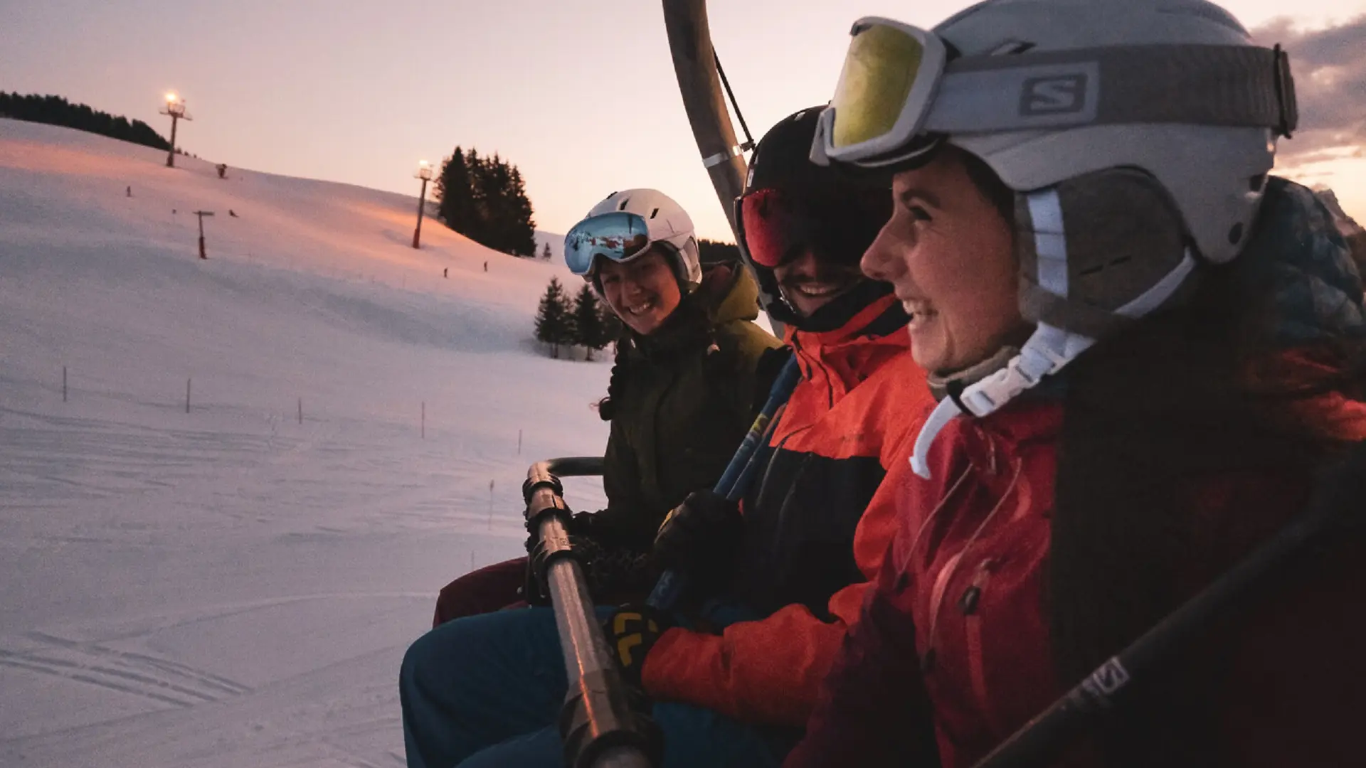 Un groupe de skieurs sur en télésiège à la tombée de la nuit avant de rejoindre les pistes du domaine de ski alpin du Grand-Bornand ouvrertes en nocturne