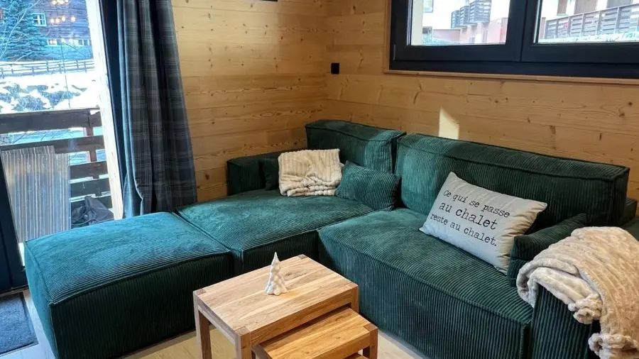 Bright living room with sofa, coffee table, windows opening on a balcony