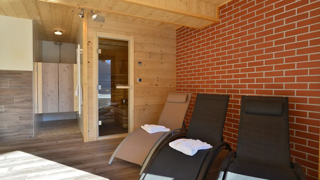 Salle détente avec sauna, douche, vélo. Accès extérieur à la terrasse avec jacuzzi.