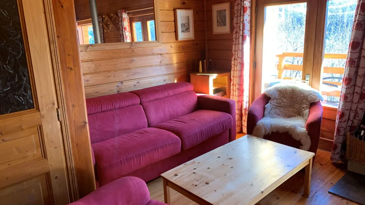 Wooden chalet living room with sofa, armchairs, coffee table, wooden furniture, window